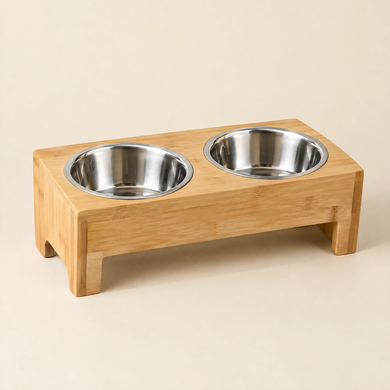 A natural wood-tone raised pet feeder stand holding two empty silver-tone bowls, on a cream background